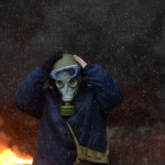Protester wearing a tear gas mask against background of the mass